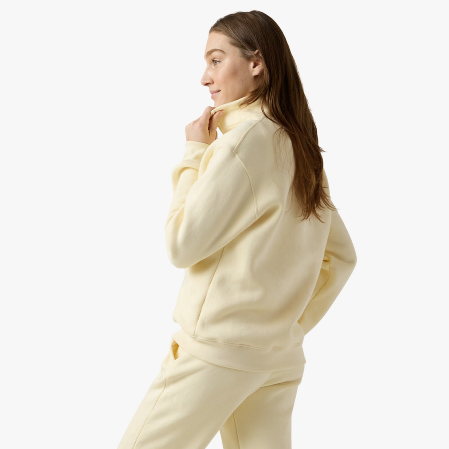 Female model wears beige half zip set and poses sideways