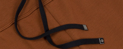 Detail of black drawstrings on brown joggers